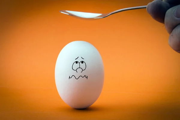 Rachando a cabeça do ovo no fundo laranja — Fotografia de Stock