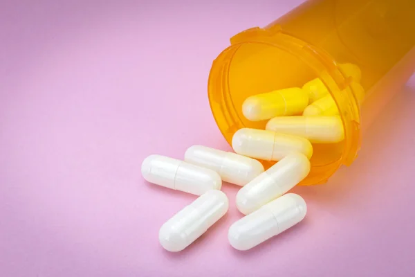 Pills spilling from an open bottle — Stock Photo, Image