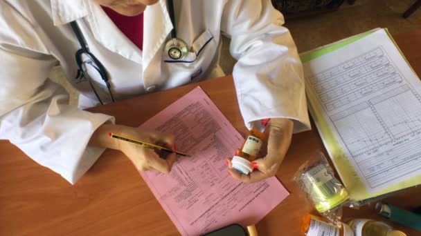 Médico haciendo la prescripción de un medicamento en una consulta del hospital — Vídeo de stock