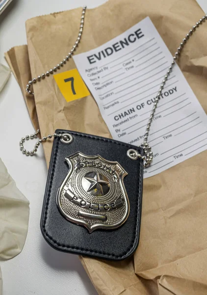 Drug bag next to police badge in crime lab, concept image