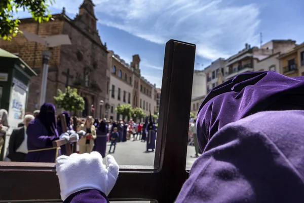 Penitent praying on his cross in front of church during Holy week — Stock Photo, Image