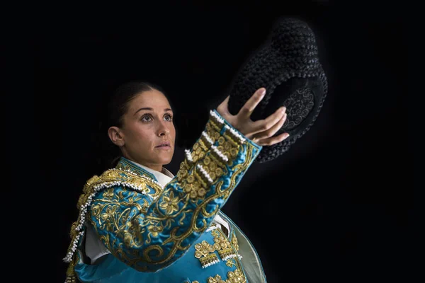 Woman bullfighter salutes with his montera in black background — Stock Photo, Image
