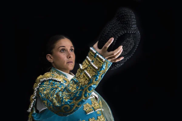 Femme torero salue avec son montera en fond noir — Photo