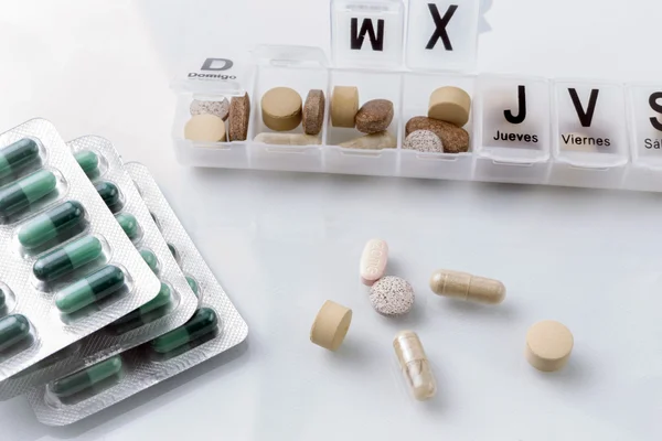 Alcune pillole in un pillbox, trattamento farmacologico giornaliero — Foto Stock