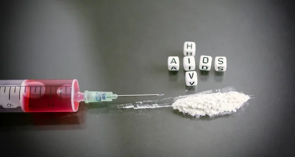 Syringe filled with blood next to a pile of cocaine, two words d — Stock Photo, Image