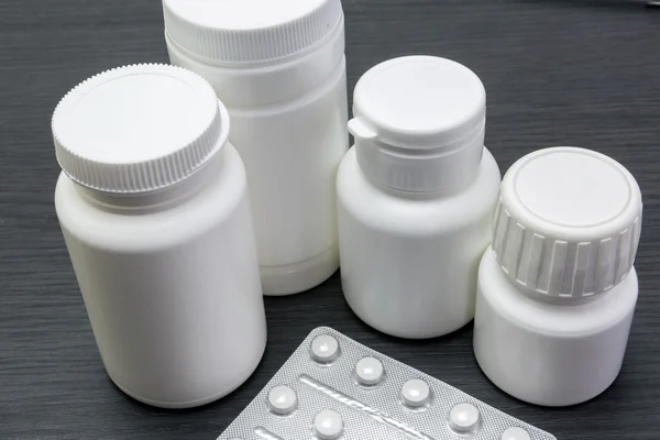 Botes de pastillas blancas con comprimidos blancos de diferentes tipos