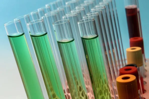 Row of test tubes in green tone — Stock Photo, Image