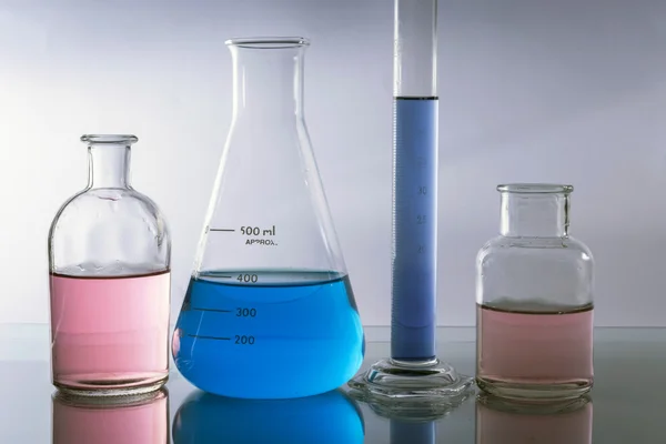 Kjemiske laboratoriekolber med farget væske inni – stockfoto