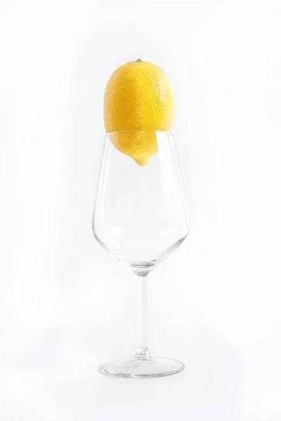 レモン入りの空のワイングラスは白い背景にあります — ストック写真