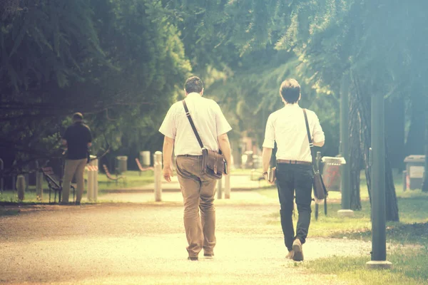 businessmen walking vintage effect, two persons on foot at the park