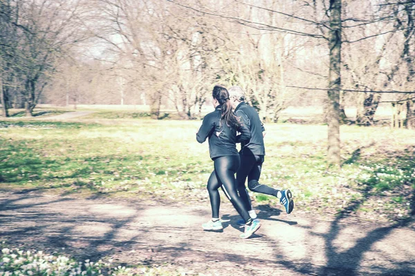 old man and young woman are running vintage effect, the couple jogging at the park