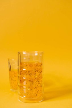 Sarı arka planda fesleğen tohumlu mango içkisi. Buzlu içecek..