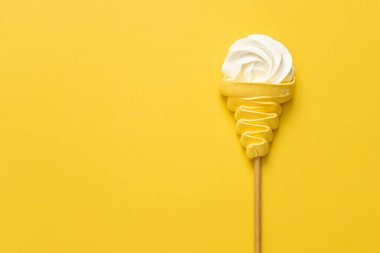 Sarı arka planda kremalı dondurma külahı 