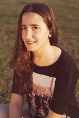 Çimenlerin üzerinde oturan genç