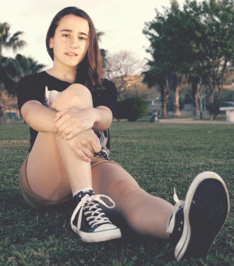 Çimenlerin üzerinde oturan genç