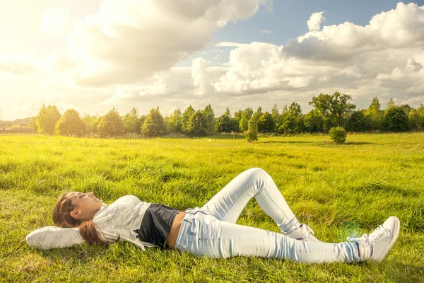 Beautiful teenager lying on the grass — Stock Photo, Image