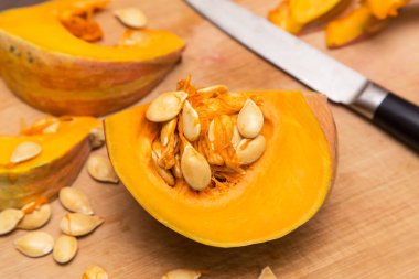 Tahta tahtada balkabağı sebzesi doğramak. Evde sağlıklı vejetaryen yemekleri pişirmek.