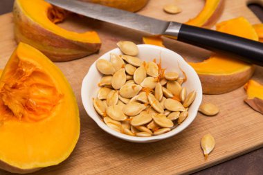 Taze çiğ kabak çekirdekleri kapanıyor. Gemide balkabağı sebzesi doğrama