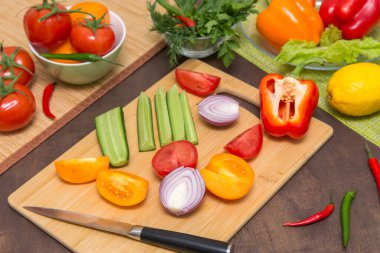 Sağlıklı vejetaryen diyet yemekleri pişirmek için farklı sebzeler. Mutfaktaki tahta tahtada sebze doğramak.