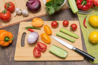 Sağlıklı vejetaryen diyet yemekleri pişirmek için farklı sebzeler. Mutfaktaki tahta tahtada salata için malzeme kesiyorum.