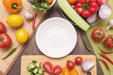 Boş beyaz tabak ve farklı taze sebzeler ve salata pişirmek için malzemeler. Diyet, oruç, vejetaryen, sağlıklı, çiğ yiyecekler.