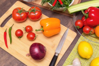 Sağlıklı vejetaryen diyet yemekleri pişirmek için farklı sebzeler. Mutfaktaki tahta tahtada salata için malzeme kesiyorum.