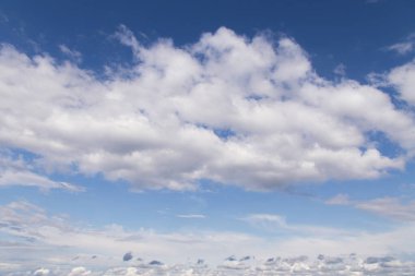 Büyük beyaz kümülüs bulutlarıyla mavi gökyüzü. Soyut arkaplan dokusu, kopyalama alanı