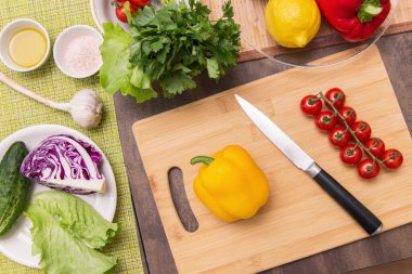 Different vegetables on table for cooking healthy vegetarian vegan diet food. Cutting vegetable for salad on wooden board on kitchen