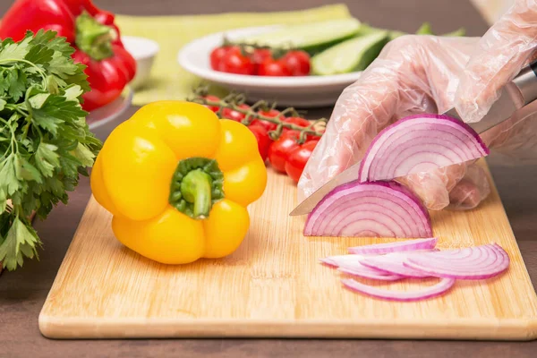 셰프는 채식주의자 식생활 음식을 요리한다 보라색 양파와 채소를 셀로판 장갑을 — 스톡 사진