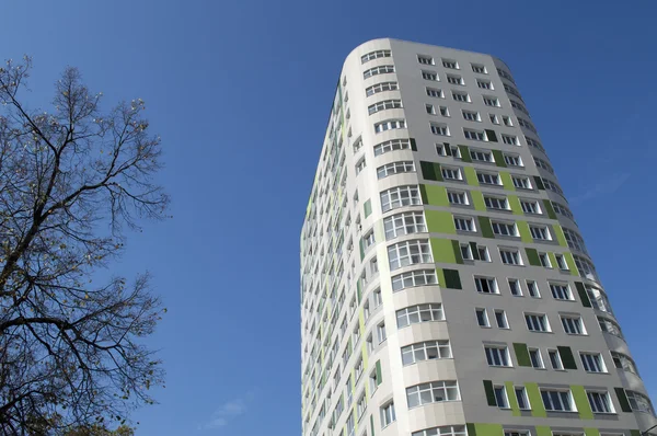 Den nye beboede multi-etagers bygning mod en klar himmel - Stock-foto