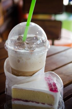 Latte sanat kahve Kupası ahşap masa ve vintage tarzı içinde kek.