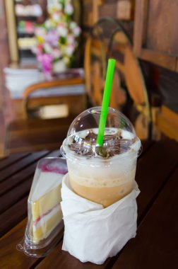 Latte sanat kahve Kupası ahşap masa ve vintage tarzı içinde kek.