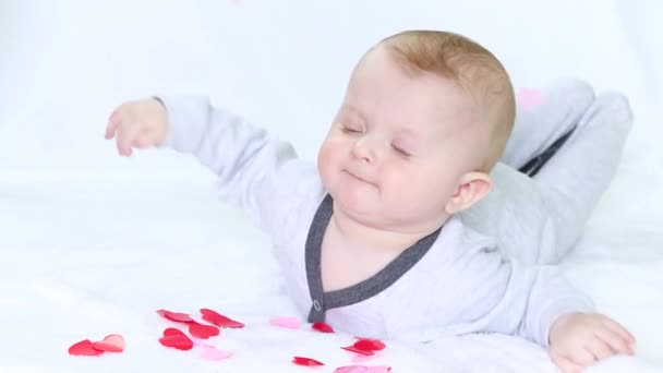 Liebenswertes Baby Blickt Auf Herzförmiges Konfetti Das Von Oben Herabfällt — Stockvideo
