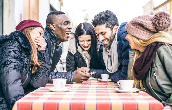 Amigos mirando el smartphone en un bar — Foto de Stock