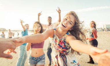 Group of friends having fun and dancing on the beach clipart