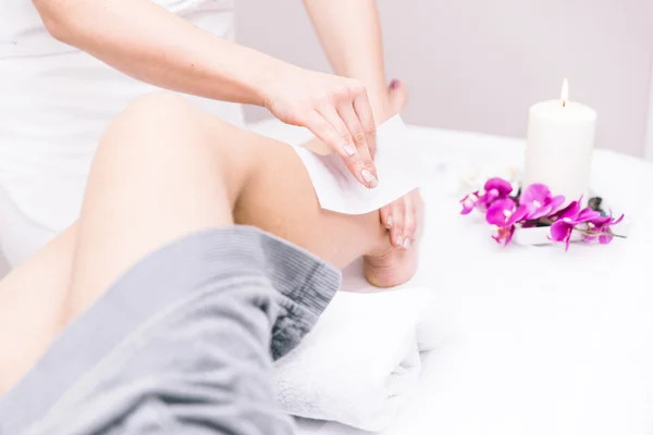 Mujer haciendo cera en sus piernas en un salón de belleza — Foto de Stock