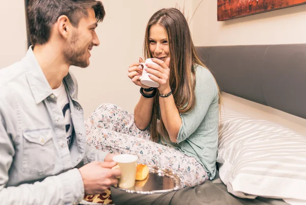 Adorável namorado trazer um pouco de café da manhã para sua namorada no m — Fotografia de Stock