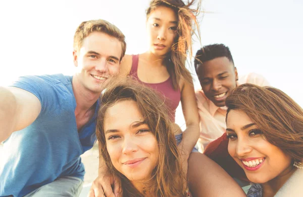 Mixed race group of friends walking in Santa monica beach and ta — Stock Photo, Image