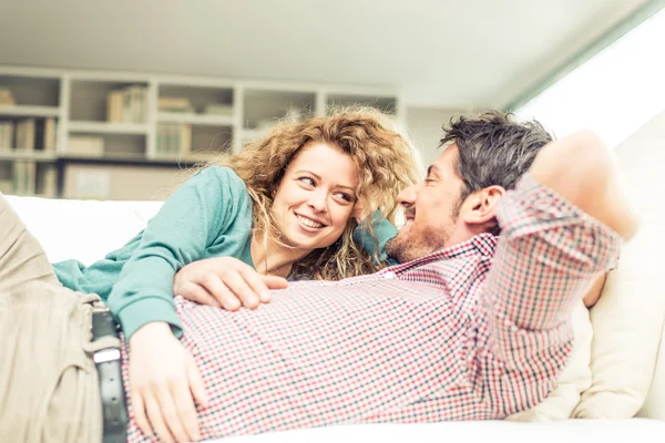 Casal de abraços no sofá — Fotografia de Stock