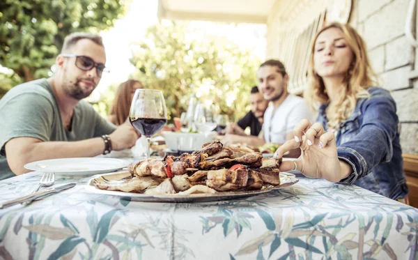 Groep vrienden maken van barbecue in de achtertuin — Stockfoto