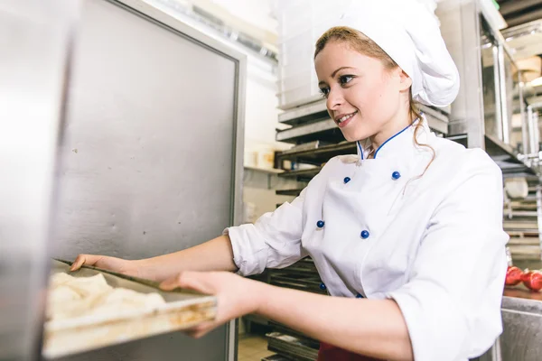 Édes croissant, péksütemény bolt előkészítése nő — Stock Fotó