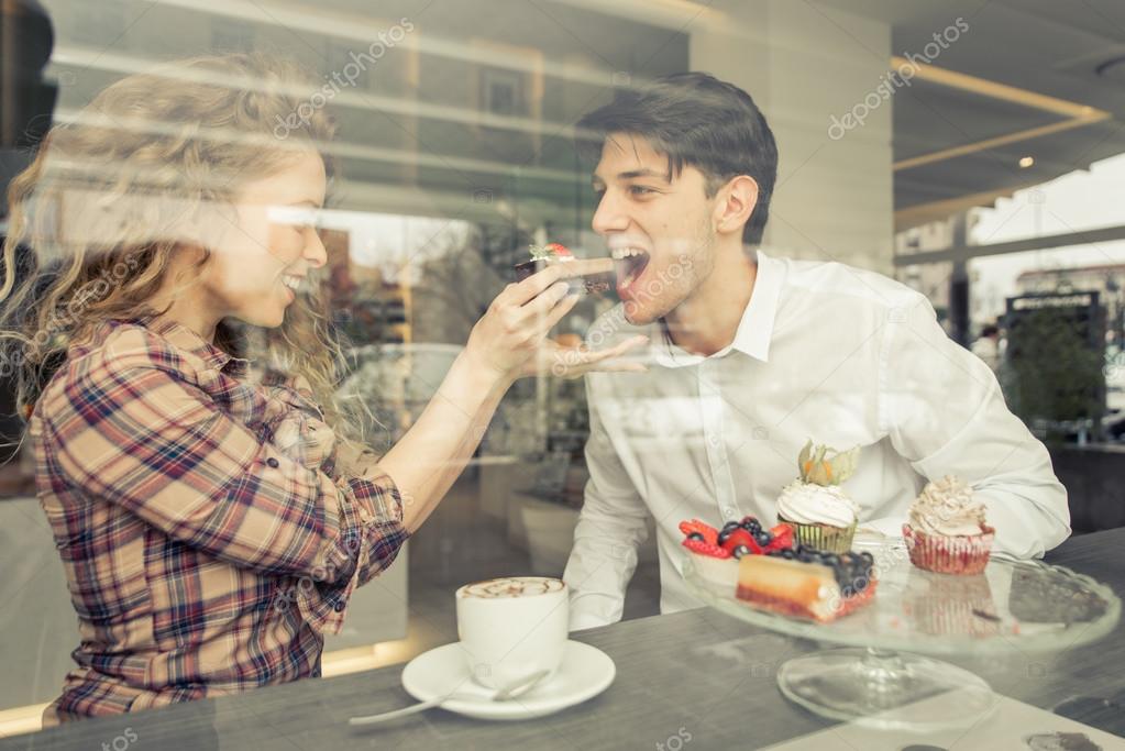 Young couple eating pastries in a pastry shop — Stock Photo