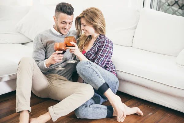 Giovane coppia bere vino in soggiorno — Foto Stock