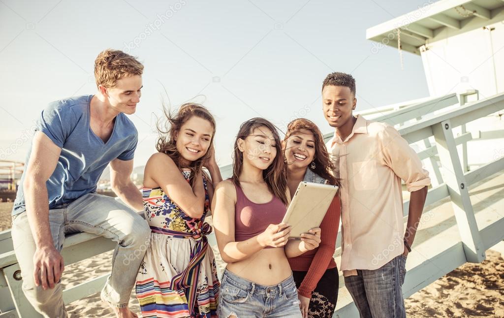 Mixed race group of friends enjoying time together on the beach 