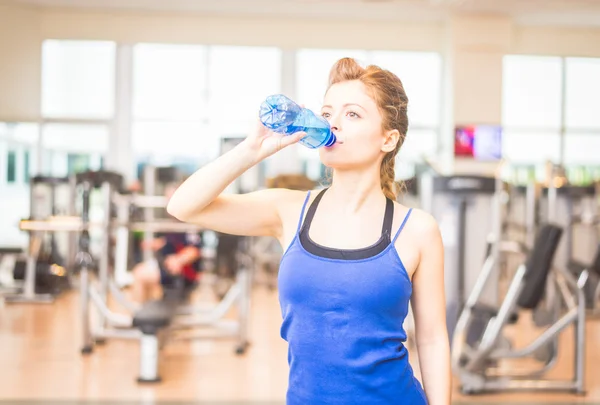 Frau trinkt Wasser in Fitnessstudio — Stockfoto