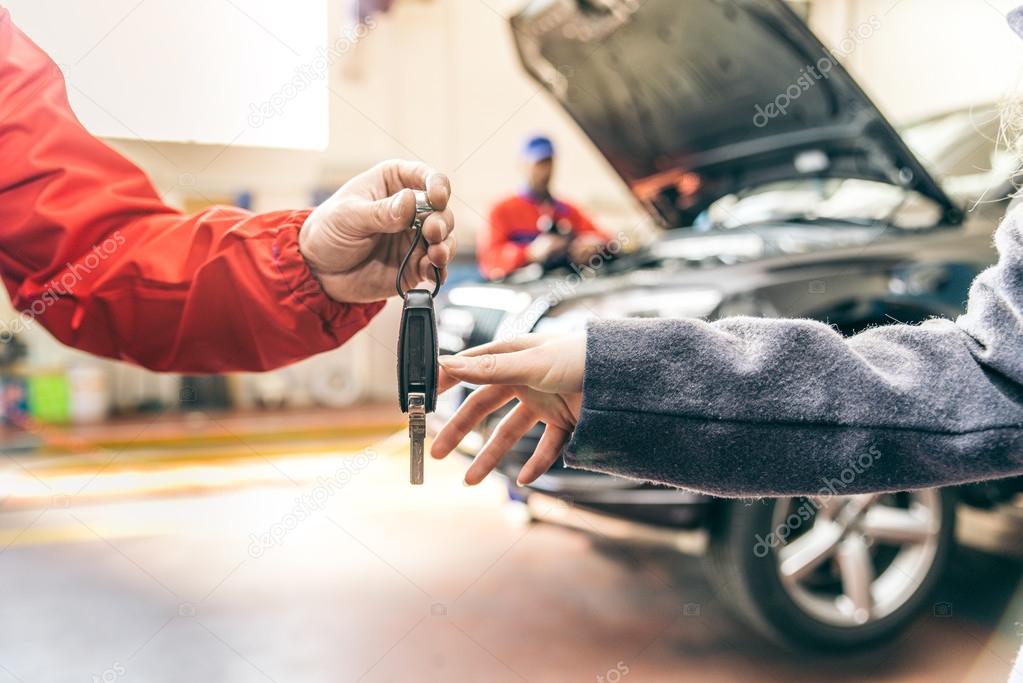 Mechanic handing woman automobile keys