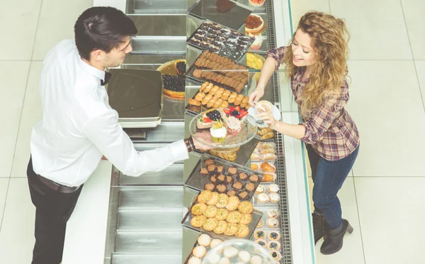 Customer woman choosing some sweet pastries — Stock Photo, Image