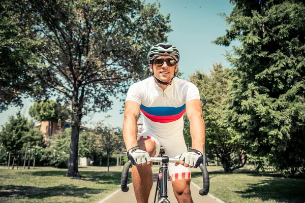 Racing cyclist training in a park — Stock Photo, Image