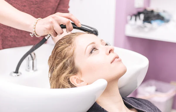 Femme faire du shampooing à la coiffeuse — Photo