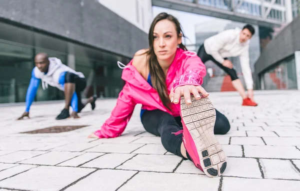 Grupo de corredores urbanos fazendo esporte em uma área urbana — Fotografia de Stock